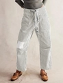 Detail of grey striped pants showing elastic drawstring waist and side pocket texture - Gray