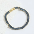 Vista dettagliata della gemma rettangolare blu scuro incastonata in un bracciale dorato - Blu Reale