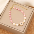 Detail of pink beaded bracelet with enamel evil eye charm and pearls on jewelry box - Pink