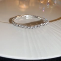 Detailopname van een sprankelende strass elastische armband op een wit porseleinen bord - Zilver