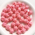 Macro view of pink star beads with rainbow luster on white tray for DIY jewelry - Rose Pink
