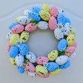 Detail of colorful Easter egg wreath with white daisies and green foliage on a door - 33cm