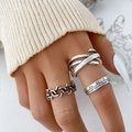 Dettaglio dell'anello a catena d'argento e ampia fascia incrociata sulla mano con luce morbida - Set Semplice di Anelli con Catena e Lettere 3 Pezzi / Argento