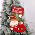 Dettaglio calze di Natale rosse e verdi con bambole di Babbo Natale in peluche e ricami - Babbo Natale