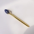 Detailed view of a gold ballpoint pen featuring a blue marble gemstone top ornament - Blue Sodalite