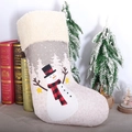 Beige linen Christmas stocking with snowman pattern leaning on books for tree decoration - Grey and White Snowman Sock