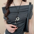 Detailed view of an ethnic necklace featuring a green ring and heart pendant on a black cord - 21# Necklace - White