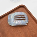 Detail showing iridescent blue acetate hair claw clip on dark wooden tray display - Pearlescent Claw / Blue Mermaid