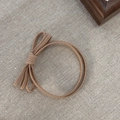 Elastic camel bow hair scrunchie shown in a simple and minimalist style on linen background - Khaki