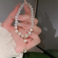 Nahaufnahme von Katzenaugen-Perlenarmband mit Herzanhänger und goldenen Akzenten - Graues Perlenherz (5# Armband-Graues Perlenherz)