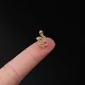 20G gold snake helix stud with white and green cubic zirconia on a fingertip - Snake Pave Style (319-8#G)