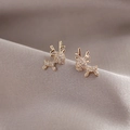 Elegant gold reindeer stud earrings with sparkling white cubic zirconia on purple silk - Gold
