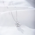 Macro detail of S925 silver floral pendant with white petals and a central zircon stone - 925 Silver / White