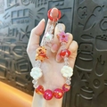 Red and white beaded phone charm featuring a cute Capybara character and star ornaments - Capybara Beaded Charm / Random Hand-painted Beads / Red