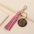 Close-up of pink leather tassel and wooden charm with gold MAMA engraving on keyring - Pink