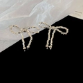 Gros plan de boucles d'oreilles nœud argentées avec cristaux brillants sur velours noir - Boucles d'Oreilles Clous Noeud Papillon avec Tige en Argent S925