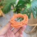 Close-up of a soft orange cotton scrunchie with ruffled edges held in hand - Orange