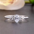 Elegante zilveren verlovingsring met ovale edelsteen op donker getextureerd vlak - US 7 / Witgoud