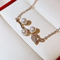 Macro shot of rose pearl pendant necklace with zircons on a white jewelry display box - Gold
