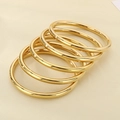 Close-up of five stacked 18k gold plated minimalist 6mm hollow stainless steel bangles - Gold 5-Piece Set
