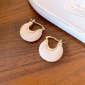 Close-up of gold C-shaped hoop earrings with cream marble resin on dark wood background - Ear Buckle - Creamy White Marble Texture