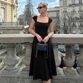 Detail shot of a black square-neck A-line dress with a lace-up back against an Eiffel Tower backdrop - S / Black