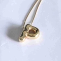 Macro detail of polished 18K gold-plated balloon style letter P pendant with a shiny finish - Letter P