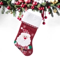 Détail d'une chaussette de Noël rouge et blanche avec Père Noël sur un sapin décoré - Père Noël