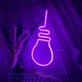 Bulb-shaped purple LED neon light sign hanging on a white grid wall for room decoration - 1-2W / Bulb Pink