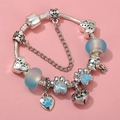 DIY charm bracelet featuring blue glass beads, paw print charms, and a small bell pendant - Sl023318/1216-3