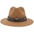 Close-up of Western cowboy hat with turquoise stone, embroidery, and tassel detail - Camel