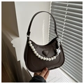 Close-up of brown leather bag with embossed heart and large pearl bead strap detail - Brown