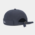 Close-up of the fish embroidery and adjustable metal buckle on a navy cotton docker cap - Dark Gray