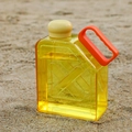 Square yellow sports water bottle with beige lid and orange handle on beach sand - Yellow