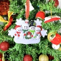 Resin 4-person snowman family ornament with festive scarves and wreath hanging on a tree - 4 People Snowman Family