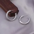 Polished silver-tone C-shaped hoop earrings displayed on premium wood and silk - E-047---Platinum 25mm