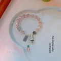 Pink crystal cat bracelet with silver charms in a heart-shaped ceramic dish - Pink Crystal Peanut Abacus Fortune Cat Bracelet