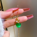 Macro detail of apple pendant necklace featuring green cat eye stone and golden leaf - Green Apple Style (G327)