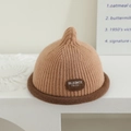 Detailed knit texture of a brown baby pointy hat with a rolled brim and leather logo - Letter Tag - Khaki