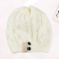 Detailed view of the hollow leaf pattern and decorative buttons on white knit beanie - Adjustable / White