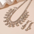 Vista macro di un set di collana e orecchini floreali con strass di cristallo lucenti - Set di strass a fiore d'argento