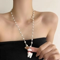 Collier de perles argenté avec pendentif animal blanc et nœud rouge sur un mannequin - Type B Collier Perle Faon Noeud Argenté