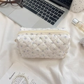 Detailansicht der gesteppten floralen Kosmetiktasche mit Reißverschluss und Textur - Beige Lila Blume