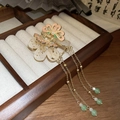 Macro shot of butterfly hairpin with enamel flowers and elegant tassels on a wooden tray - Long Tassel Butterfly Flower Style / Gold