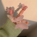 Set de pinzas de mariposa rosa mate con sombras artísticas bajo luz cálida - Juego de Pinza Mariposa / Rosa Esmerilado