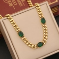 Golden cuban chain necklace with emerald green oval gemstones on a beige display box - 1# Necklace