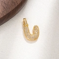 Detailed view of a gold horseshoe pendant with shimmering pavé micro-inlaid cubic zirconia - Letter U