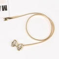 Dettaglio della cintura elastica dorata con fibbia a fiocco impreziosita da strass - 60-80cm / 14 Fiocco / Oro