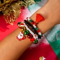 Close-up of Christmas charm bracelet with Santa, bell, and tassel charms on wrist - Black Tassel Stocking(27635-colour)
