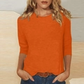 Primer plano del top naranja con cuello redondo mostrando la textura y las mangas 3/4 - Naranja